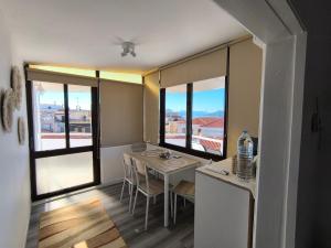 a dining room with a table and some windows at Aegina Downtown Apartments 2 in Aegina Town