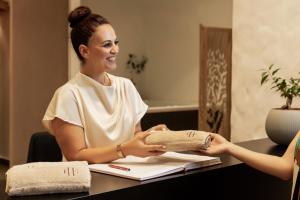 a woman sitting at a table talking to another woman at Elisabeth Boutique Hotel in Thessaloniki