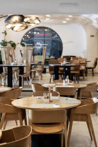 an empty restaurant with wooden tables and chairs at Elisabeth Boutique Hotel in Thessaloniki