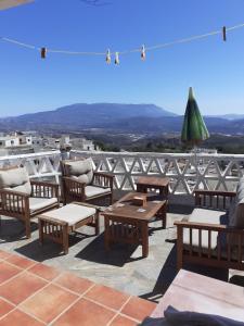 a group of wooden benches and tables on a roof at El Tinao in Yegen