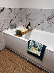 a bathroom with a bath tub with a towel on it at Beautiful, luxury house! in Higham on the Hill