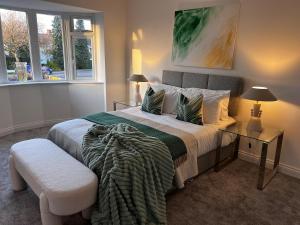 a bedroom with a bed and a table and a chair at Beautiful, luxury house! in Higham on the Hill