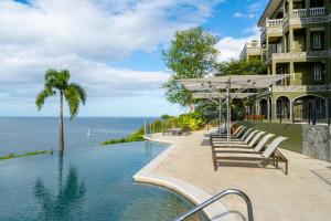 a house with a swimming pool next to the ocean at 360 Splendor 303-Ocean View Condo-Breakfast Included! in Playa Flamingo