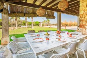 une table blanche et des chaises sur une terrasse dans l'établissement Flor de Sal a Sa Canoveta by Bebreeze, à Campos