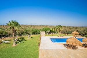 un complexe avec une piscine avec des parasols en paille dans l'établissement Flor de Sal a Sa Canoveta by Bebreeze, à Campos