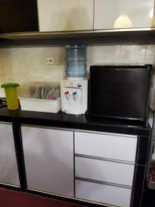 a kitchen counter with a microwave on top of it at Homestay 4H Perlis in Kangar +10 photos