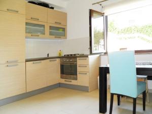 kuchnia z drewnianymi szafkami i niebieskim krzesłem w obiekcie Apartment Starcevic Filipovic w Bašce