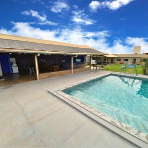 une piscine dans une cour avec une maison dans l'établissement Chacara a Grande Familia, Bairro Andorinhas Otima Nova, à Uberlândia