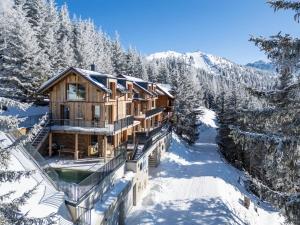 a log cabin in the snow with snow covered trees at Luxus AlmChalets Schladming-Dachstein in Gumpenberg