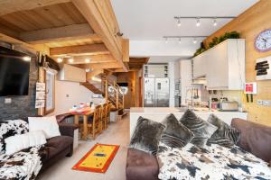 a living room with a couch and a kitchen at Luxury Avoriaz Chalet with hot tub in Avoriaz