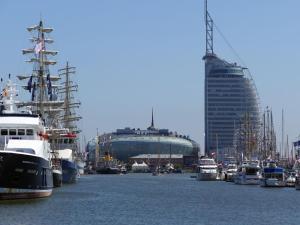 un port avec de nombreux bateaux et un grand bâtiment dans l'établissement Ferienwohnung Port Marina 419, das Hafen-Apartment in perfekter Lage!, à Bremerhaven