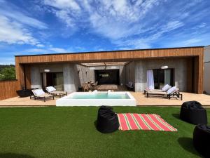 una casa con piscina e prato di Magnifique villa écologique piscine jacuzzi a Clarensac