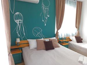a bedroom with a bed and a blue wall with drawings at Guest House Sunflowers in Pomorie