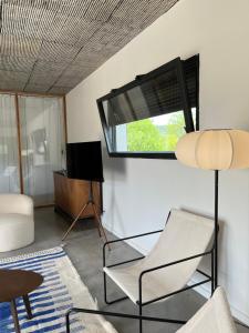 un soggiorno con una sedia e una finestra di Magnifique villa écologique piscine jacuzzi a Clarensac