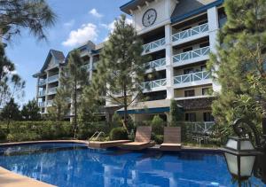 a hotel with a swimming pool in front of a building at La Freya Suite Tagaytay in Tagaytay