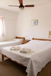 two beds in a room with a ceiling fan at Hotel Acuarium in Villa Gesell +60 photos