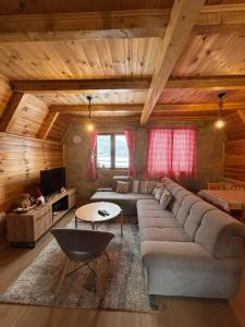 uma sala de estar com um sofá e uma mesa em Zabljak_vikendica em Žabljak mais 37 fotografias