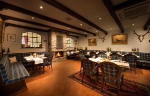 a restaurant with tables and chairs and a fireplace at Landgut Ramshof in Willich