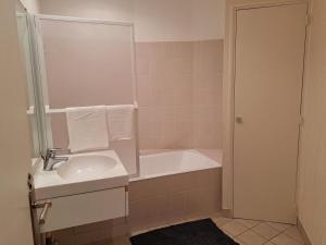 a bathroom with a sink and a bath tub at Quai de la Gare, Appartement étape, 2 chambres, face à la Gare in Châtellerault +19 photos