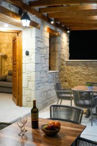 a bottle of wine and a bowl of fruit on a table at Vouni Calais in Vouni +23 photos