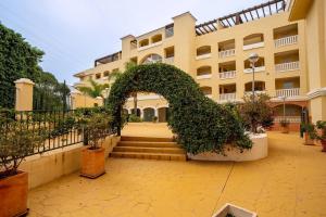 a large building with an arch in front of it at Espacioso apartamento en Mijas con parking privado in Sitio de Calahonda