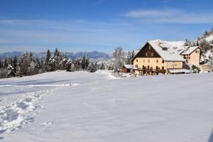 pokryte śniegiem pole z domem w oddali w obiekcie Gite montagnard du Fanget w mieście Auzet