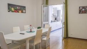 a kitchen and dining room with a white table and chairs at Terrasini Downtown Little Square in Terrasini