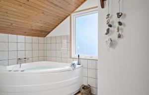 a white bath tub in a bathroom with a window at Three-Bedroom Holiday Home In Thisted in Nørre Vorupør