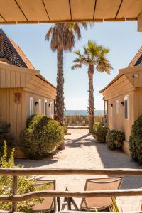 a patio with two houses and palm trees at Toison D'or in Saint-Tropez