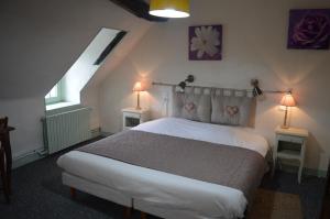ein Schlafzimmer mit einem Bett und zwei Lampen an zwei Tischen in der Unterkunft Le Relais du Morvan in Vézelay