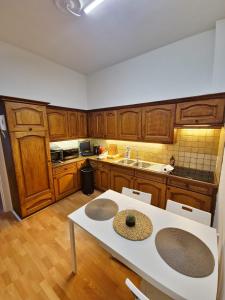 eine Küche mit Holzschränken und einem weißen Tisch in der Unterkunft Sauna, Atomium, Expo Brussels, Stadium Roi Baudoin, Kinepolis, Planetarium, Centre ville Brussels in Brüssel