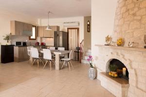 a kitchen and dining room with a table and a fireplace at Villa Natalia in Afitos