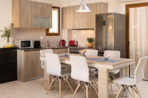 a kitchen with a table and chairs in a kitchen at Villa Natalia in Afitos +35 photos