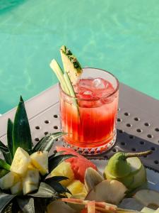 a drink next to a plate of fruit next to a pool at Wolf Suites in Antalya