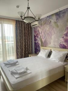 a bedroom with a large bed with a floral wall at Admiral Plaza Apartments in Sunny Beach +151 photos