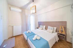 a bedroom with two beds with towels on them at City Center Apartment Project by Cretan Houses in Heraklio