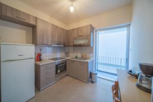a kitchen with wooden cabinets and a white refrigerator at City Center Apartment Project by Cretan Houses in Heraklio