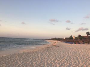 einen Strand mit dem Meer und Menschen darauf in der Unterkunft Stunning 2Bd 2Ba 5 Star Golf Resort in Chacalal