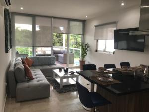 ein Wohnzimmer mit Sofa und Tisch in der Unterkunft Stunning 2Bd 2Ba 5 Star Golf Resort in Chacalal