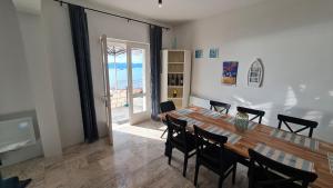 a dining room with a large wooden table and chairs at Villa More in Postup