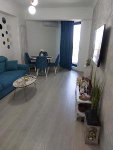 a living room with a blue couch and a table at Apartament Solid Resindence Butoaie in Mamaia