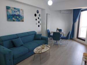 a living room with a blue couch and a table at Apartament Solid Resindence Butoaie in Mamaia