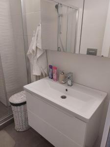 a white bathroom with a sink and a mirror at Apartament Solid Resindence Butoaie in Mamaia +16 photos