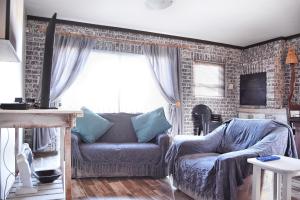 a living room with a couch and a brick wall at Beachfront Selfcatering in Hentiesbaai