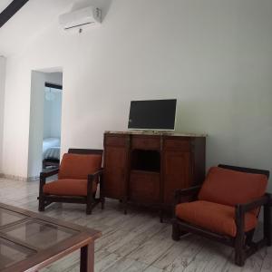 un soggiorno con 2 sedie e una TV su un armadio di Amaneceres de Cabalango a Cavalango