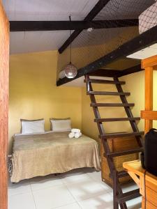 a bedroom with a bunk bed and a ladder at Pousada Aventurine Noronha in Fernando de Noronha