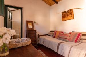 a bedroom with a bed and a mirror and a table at Los Arcabuceros Casa Hotel Boutique in Tilcara