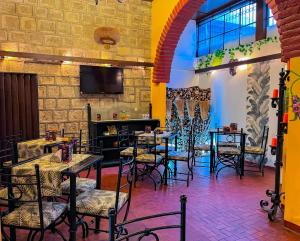 a restaurant with tables and chairs and a tv at Hotel Rodelu in Latacunga