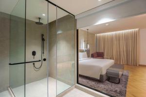 贾朗达尔Park Inn by Radisson Jalandhar的带淋浴的浴室和带床的卧室