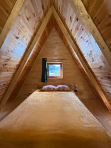 uma cama no sótão de um chalé de madeira em Zabljak_vikendica em Žabljak